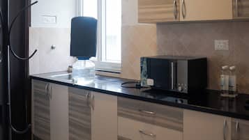 Eine moderne Küche mit Wasserspender, Mikrowelle und Kaffeemaschine.