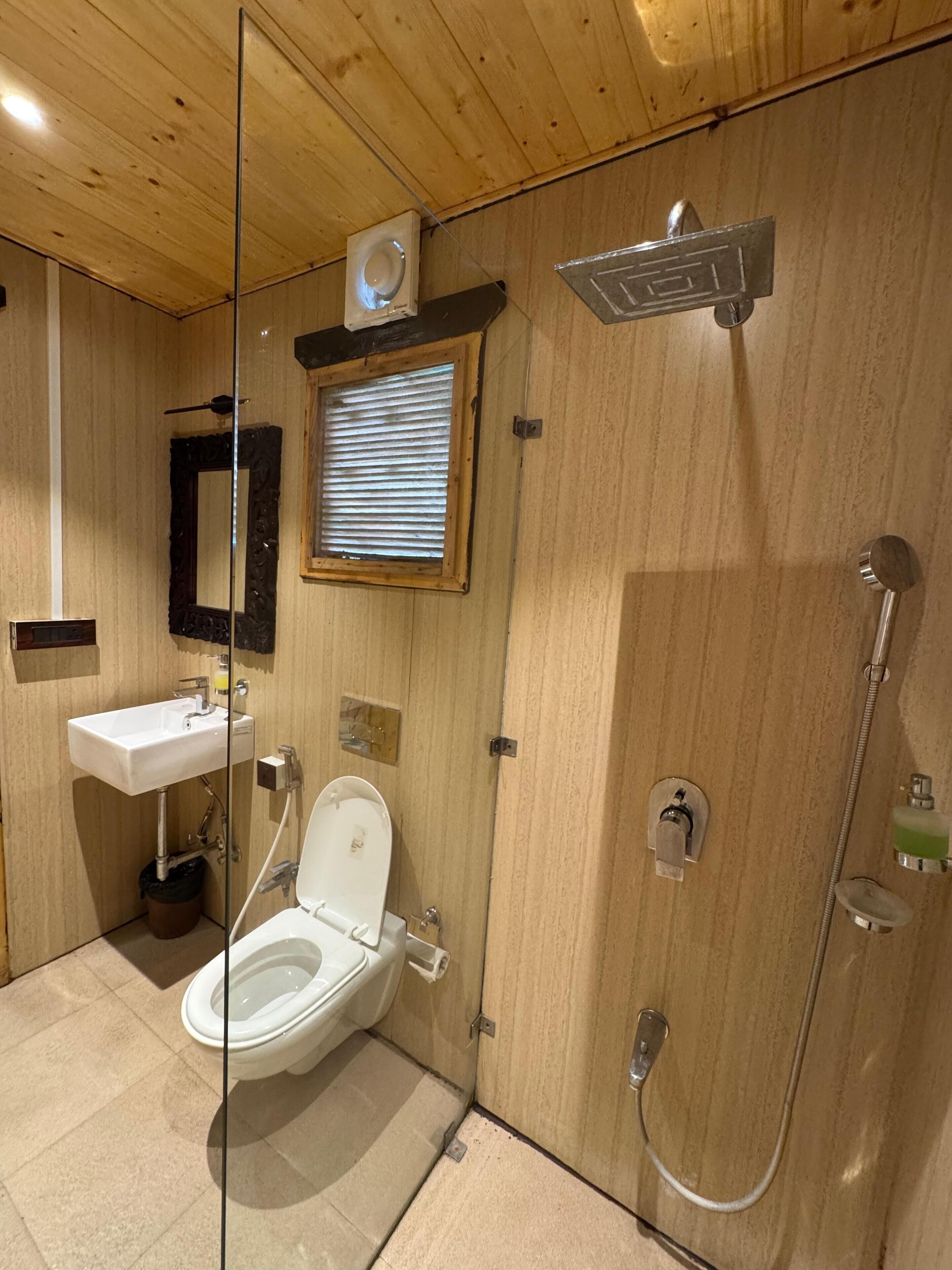 A compact bathroom with a toilet, sink, and shower.
