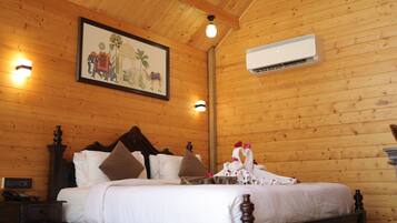 Habitación con paneles de madera, una cama, una mesita de noche, aire acondicionado montado en la pared y un cuadro enmarcado.