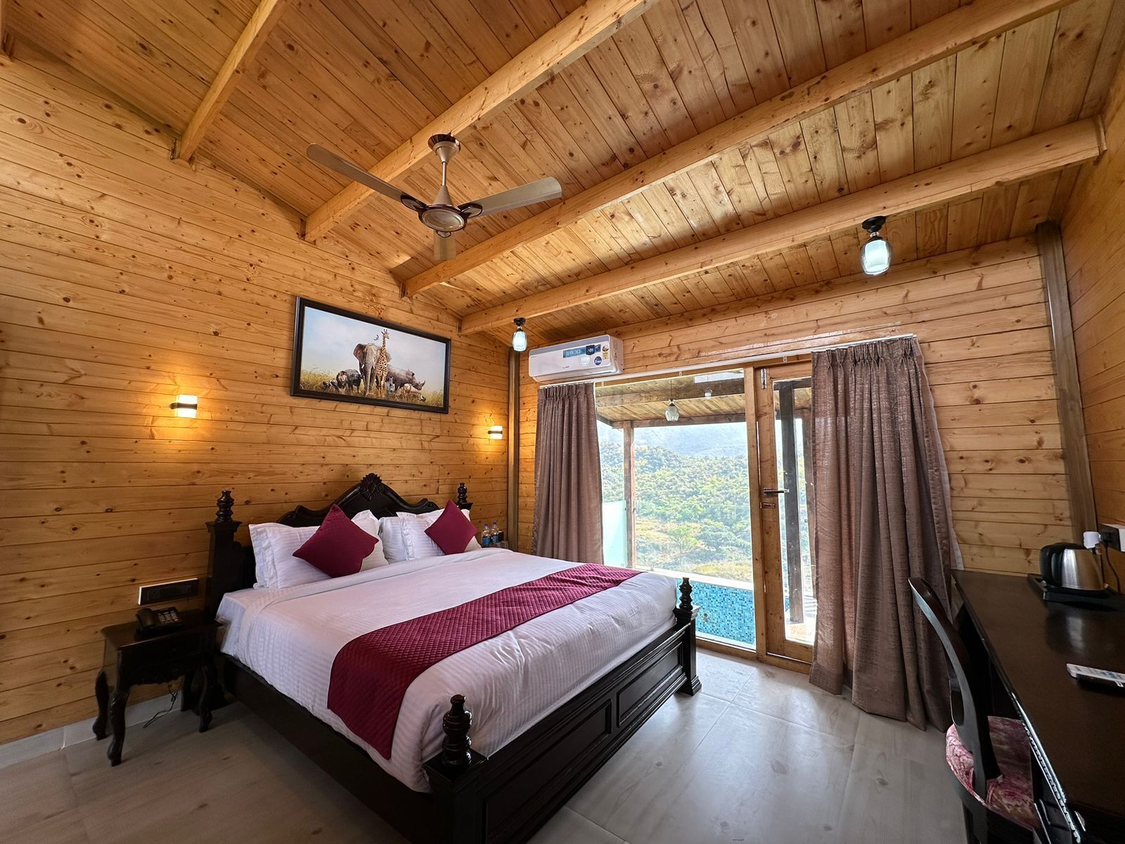 A wooden-paneled bedroom with a bed, a ceiling fan, a painting, and a view through the door.