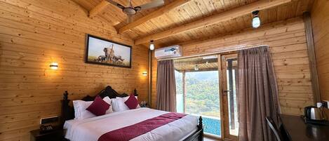 Quarto com painéis de madeira, uma cama, um ventilador de teto, um quadro e vista pela porta.