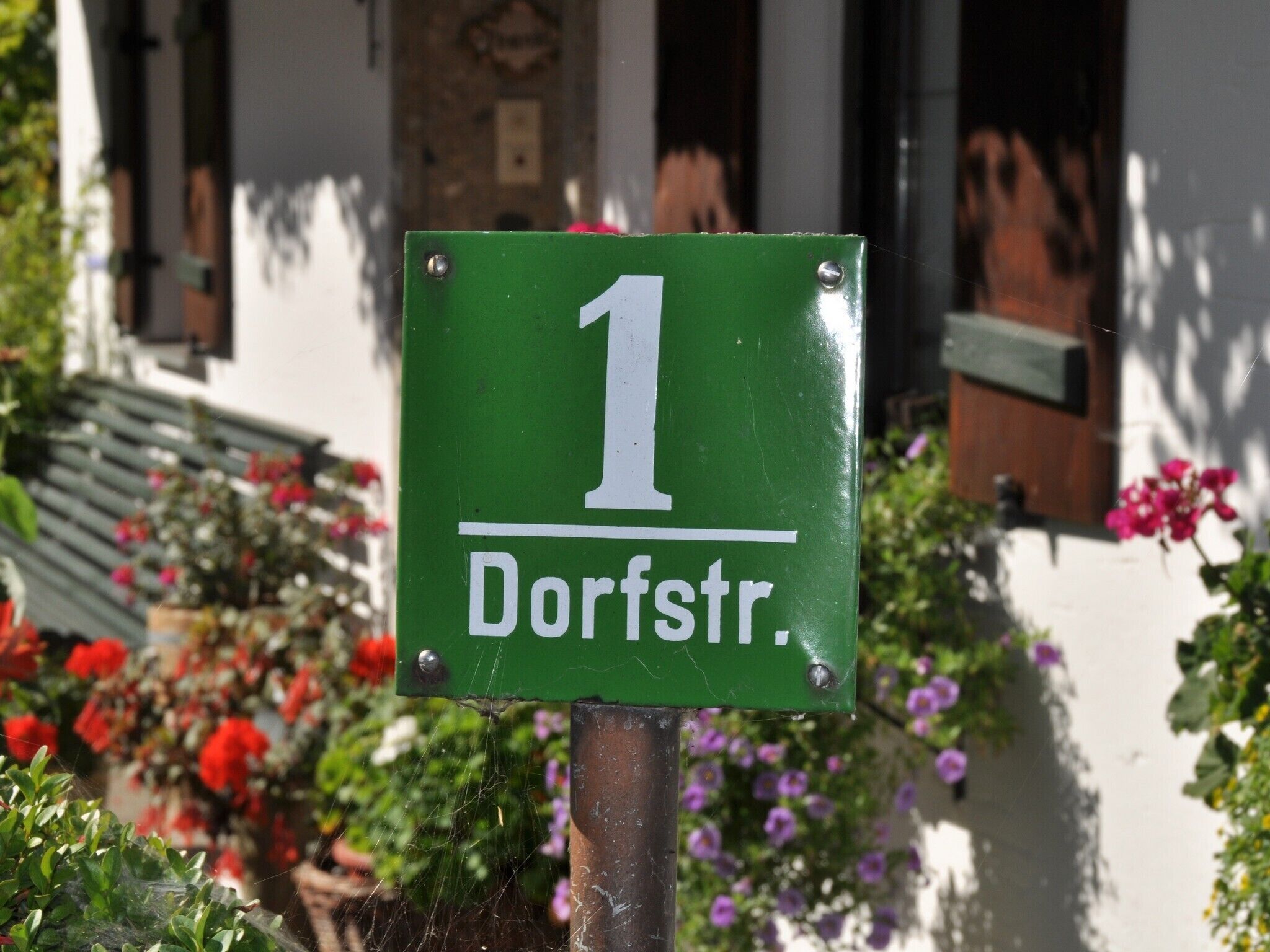 Segnaletica verde con il numero 1 e la scritta 'Dorfstr'.