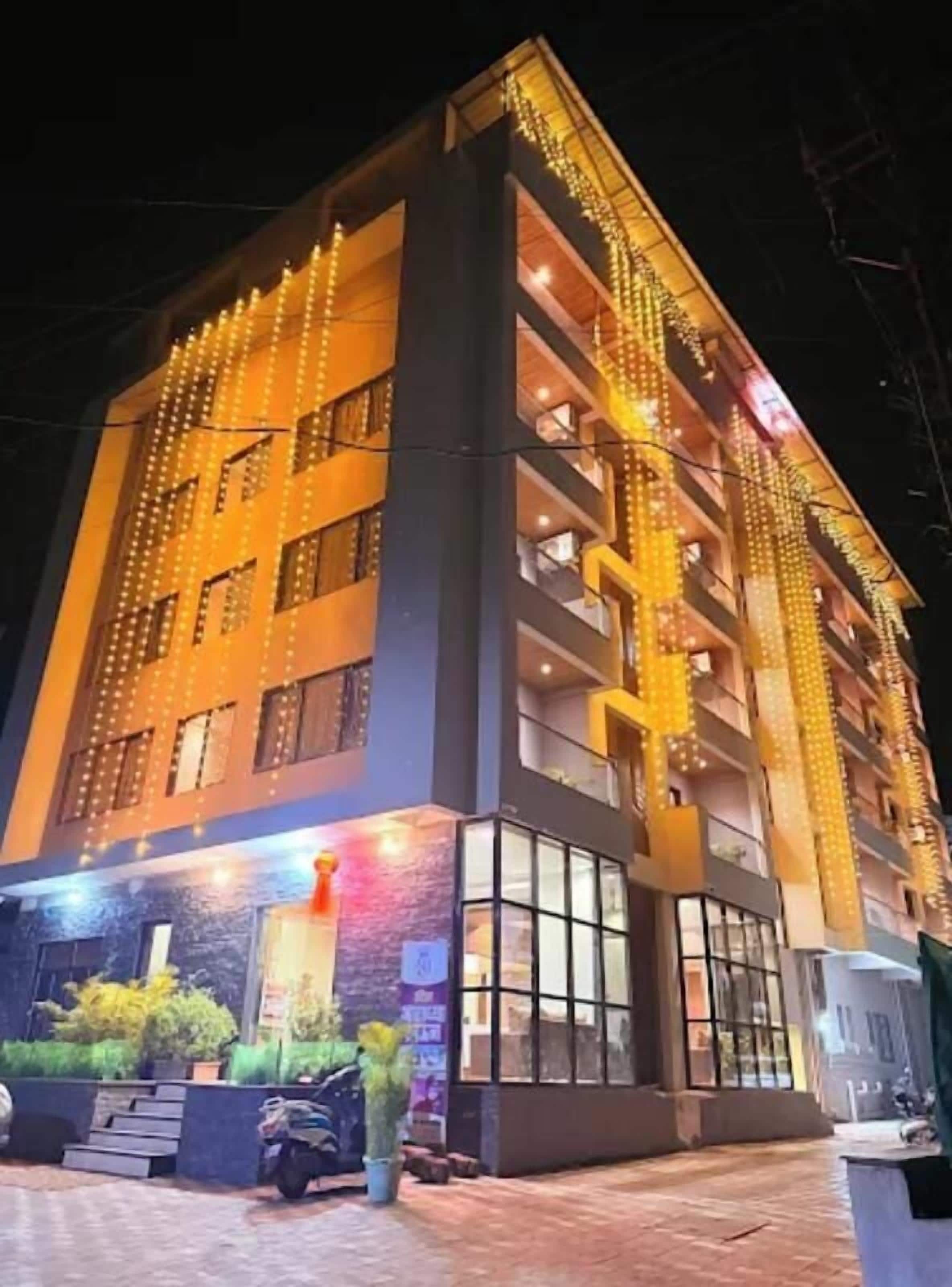 A multi-story building with balconies and string lights.