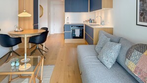 Un appartement moderne comprenant un coin repas, une cuisine et un salon.