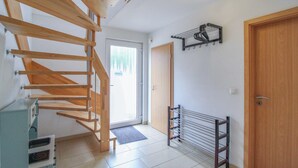 A modern interior with a wooden staircase, a metal drying rack, and a door leading to another room. - Pet friendly home in Röbel with WiFi (Röbel)