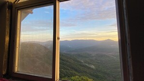 A room with a large window overlooking a mountainous landscape. - BLOOMS AND BERRIES AGRO TOURISM (Kalamgaon kalamkar)