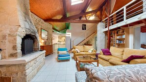 A cozy living room with a stone fireplace, a staircase, and a bookshelf. - Stunning home in Chenac-Saint-Seurin-d' (Chenac-Saint-Seurin-d')