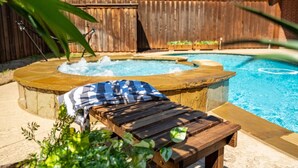 A backyard with a wooden deck, a hot tub, and a swimming pool. - Designer-Styled Modern Farmhouse w/ Heated Pool (Allen)