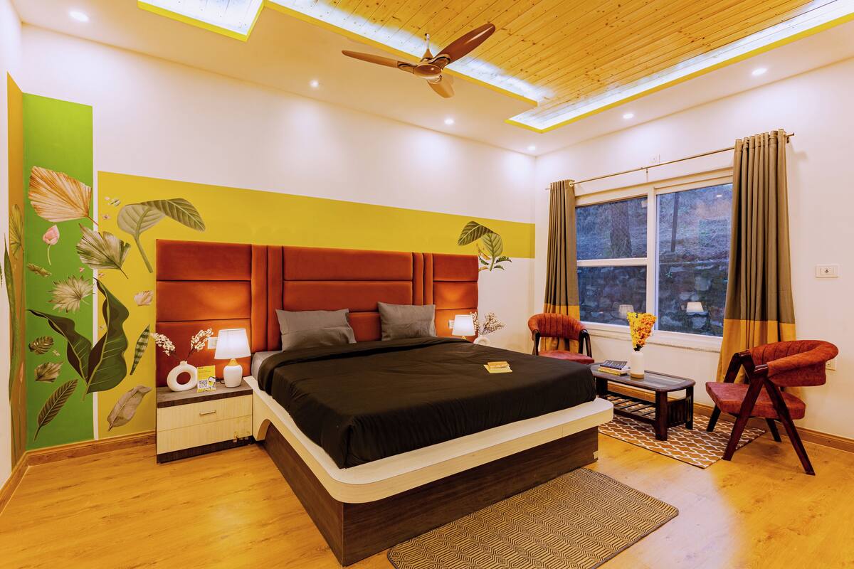 A modern bedroom with a large bed, a nightstand, a desk, and a chair.