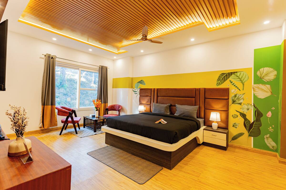 A modern bedroom with a large bed, bedside tables, a desk, and a chair.