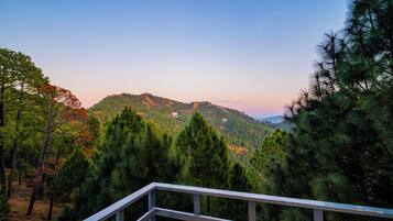 Un paisaje montañoso con bosques densos y un cielo despejado.