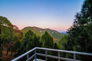 A mountainous landscape with dense forests and a clear sky.