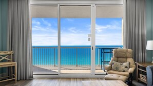 A room with a sliding glass door leading to a balcony with a view of the ocean. - Majestic 1710 | Beach-Front Gulf Views - 2BR/2BA (Panama City Beach)
