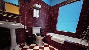 A bathroom with a checkered floor, a white sink, a toilet, a bathtub, and a window with blinds. - Wanning 911 Surf Club (Wanning)