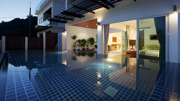 A modern hotel with a swimming pool, a covered outdoor area, and a well-lit interior. - Kamala Falls 3BR Seaview w Private Pool (Kamala)