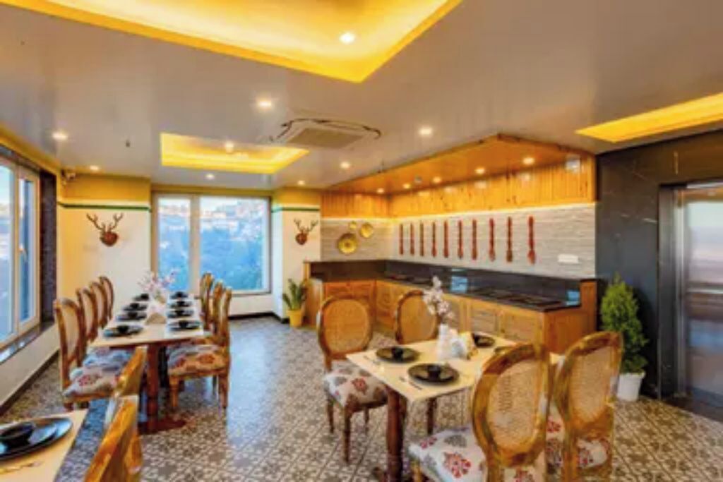 Un restaurante con mobiliario de madera, suelo de baldosas y una zona de cocina con armarios de madera y estufa.