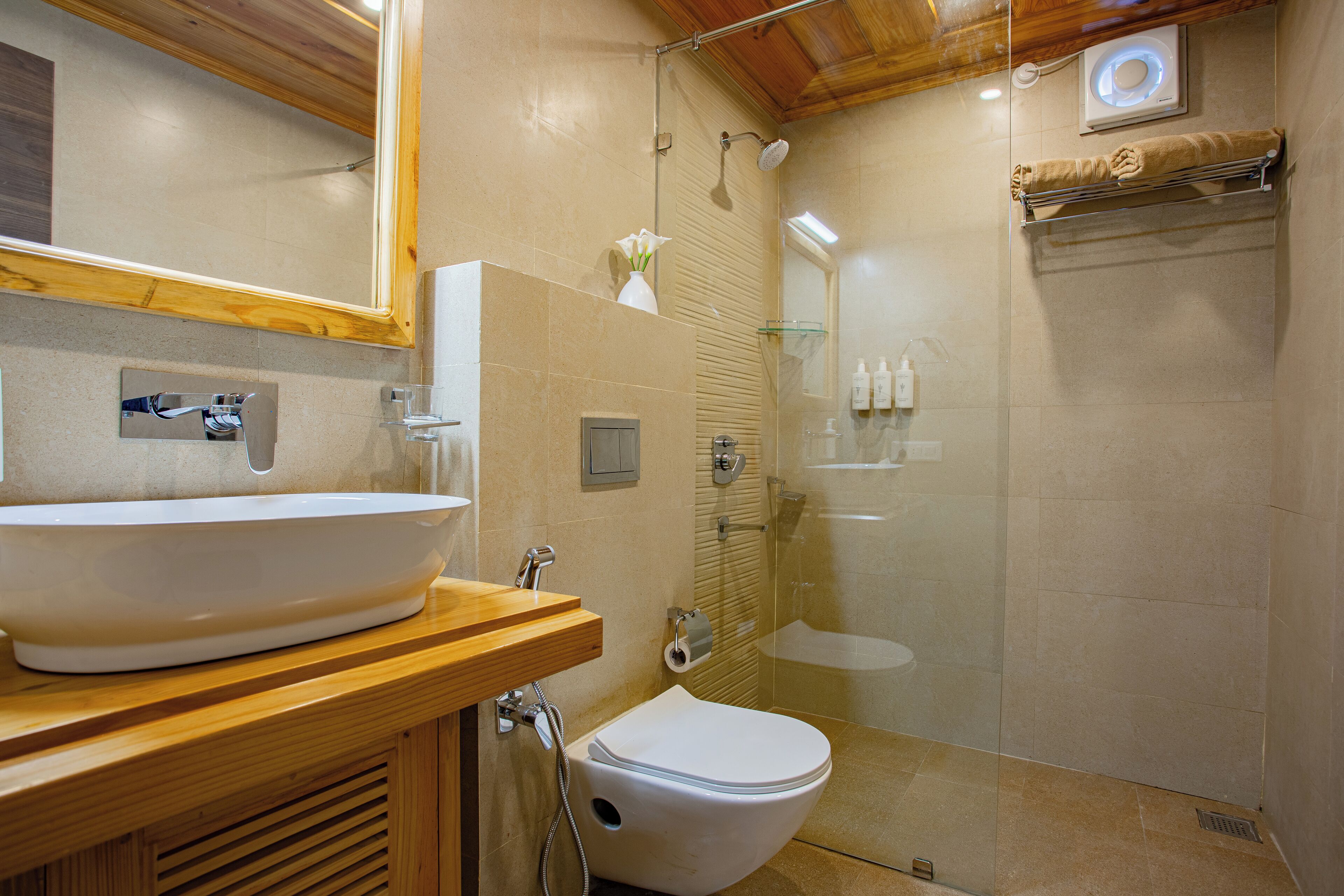 A bathroom with a large white sink, a toilet, and a glass-enclosed shower.