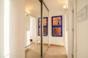 A hallway with a glass door, a mirror, and artwork on the wall. - Lemon Tree House – Simple, Bright, and Peaceful (Bari)