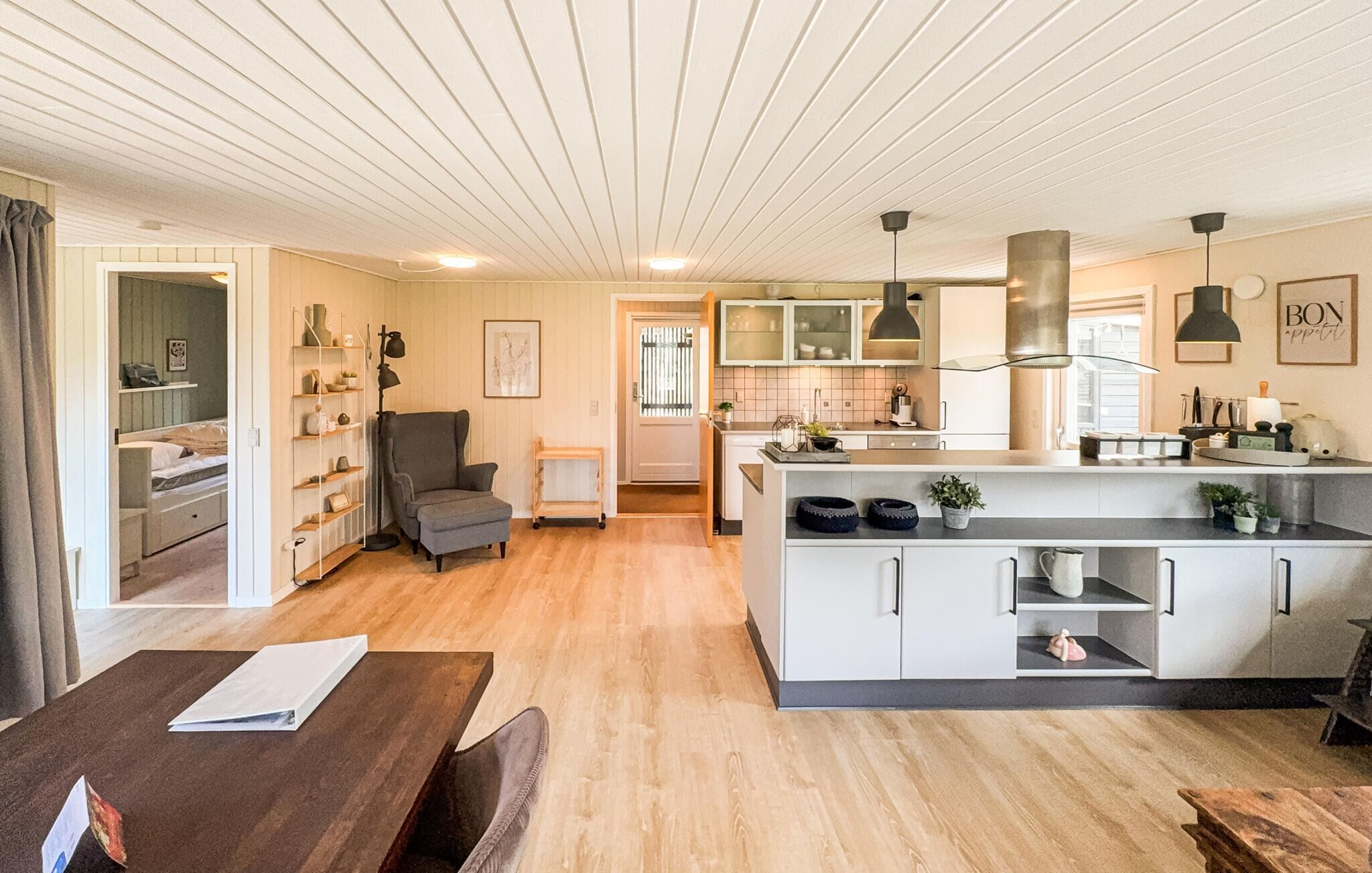 A modern kitchen with a central island, built-in cabinets, and pendant lighting.