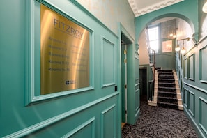 A hallway with a sign indicating room assignments for Fitzroy Hotel. - Guestready - The Fitzroy Hotel (London)