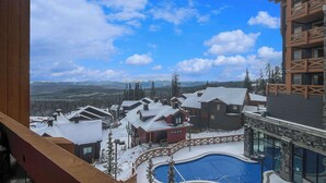Ein Resort mit Pool, verschneiten Außenanlagen und Bergblick.