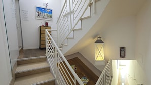 Un escalier avec des rampes blanches et une lanterne.