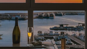 Une vue depuis une fenêtre donnant sur une marina où sont amarrés des bateaux.