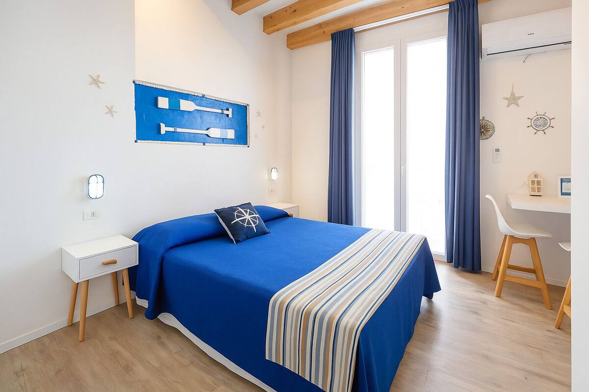 A bedroom with a bed, a desk, and a chair.