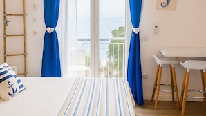 Une chambre à coucher avec un lit, une échelle en bois, un bureau et une vue par la fenêtre.