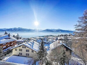 A snow-covered village with traditional buildings, a clear sky, and mountains in the background. - Elysée 11 by Interhome (Crans-Montana)