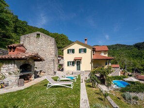 A stone building with a small tower, a yellow house with green shutters, and a swimming pool. - Sirotnjak by Interhome (Lovran/Lovranska Draga)