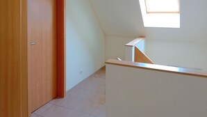 A narrow hallway with a wooden door, a white wall, and a small window. - Gorgeous home in Röbel with sauna (Röbel)