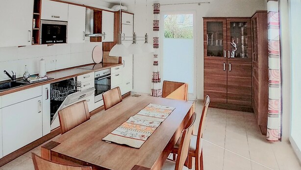 A modern kitchen with a dining table, chairs, and a built-in oven. - Gorgeous home in Röbel with sauna (Röbel)