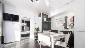 Un espacio habitable moderno y funcional, con kitchenette, comedor y dormitorio.