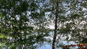 A wooden deck with a 'No Entry' sign, a gravel path leading to a lake, and dense trees surrounding the area. - Tiny house on Lake Murner with hot tub (Wackersdorf)