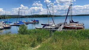 A marina with several sailboats docked, surrounded by grassy areas and a clear sky. - Tiny house on Lake Murner with hot tub (Wackersdorf)