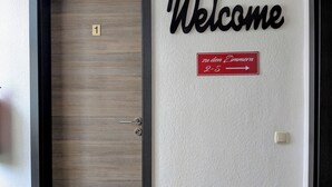 En dør med et nummer, et 'Welcome' skilt og en skiltepejling til værelser 2-5.
