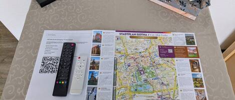 A city map of Gotha on a table with a remote control, a tissue box, and a QR code.