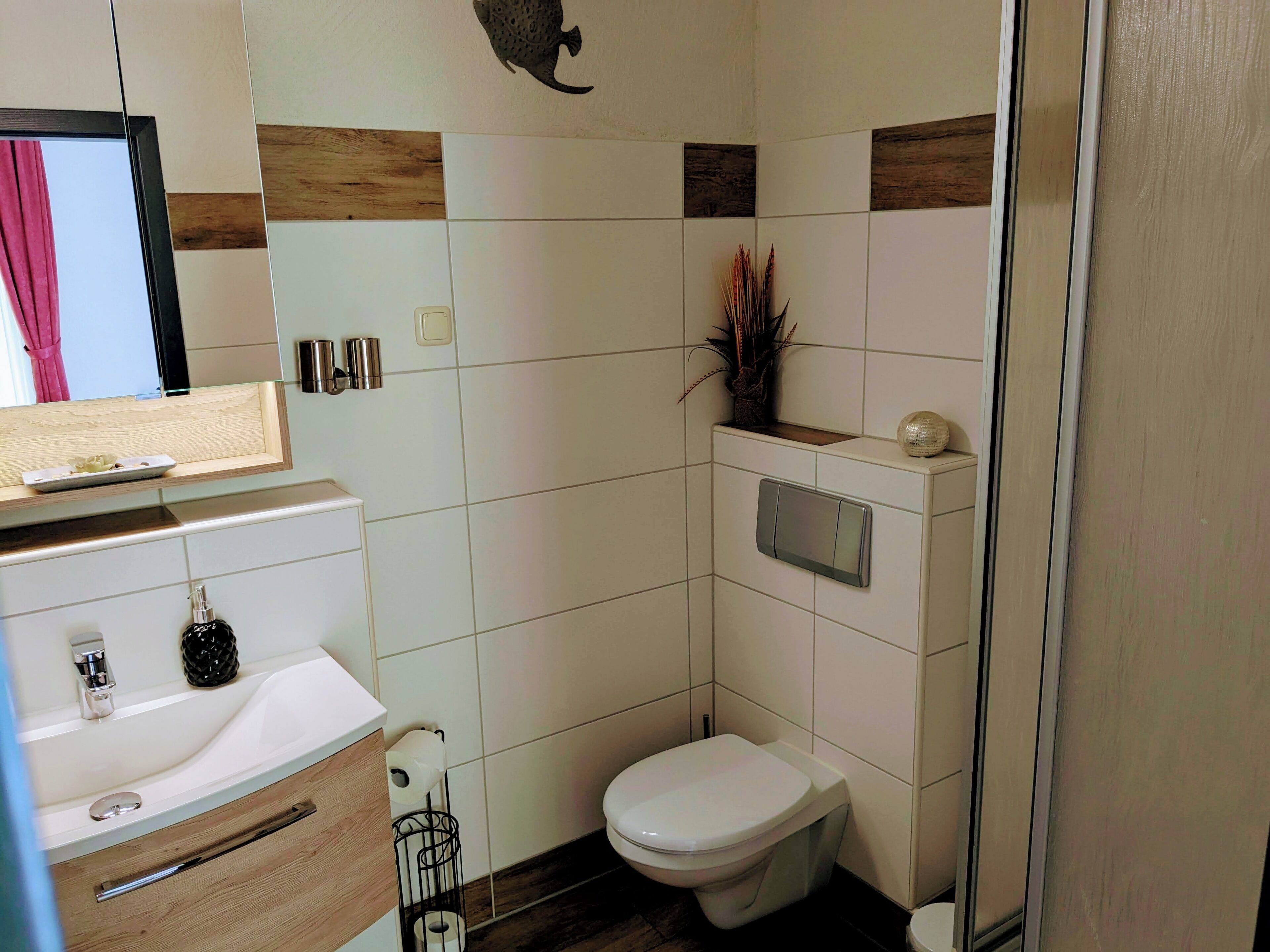 A modern bathroom with a toilet, sink, and shower area.