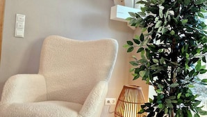 A room with a plush armchair, a woven floor lamp, and a potted plant. - Select-Home 6 - Haus Altstadt (Neunburg vorm Wald)