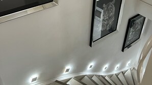 Una escalera con barandilla y un muro con cuadros de animales.