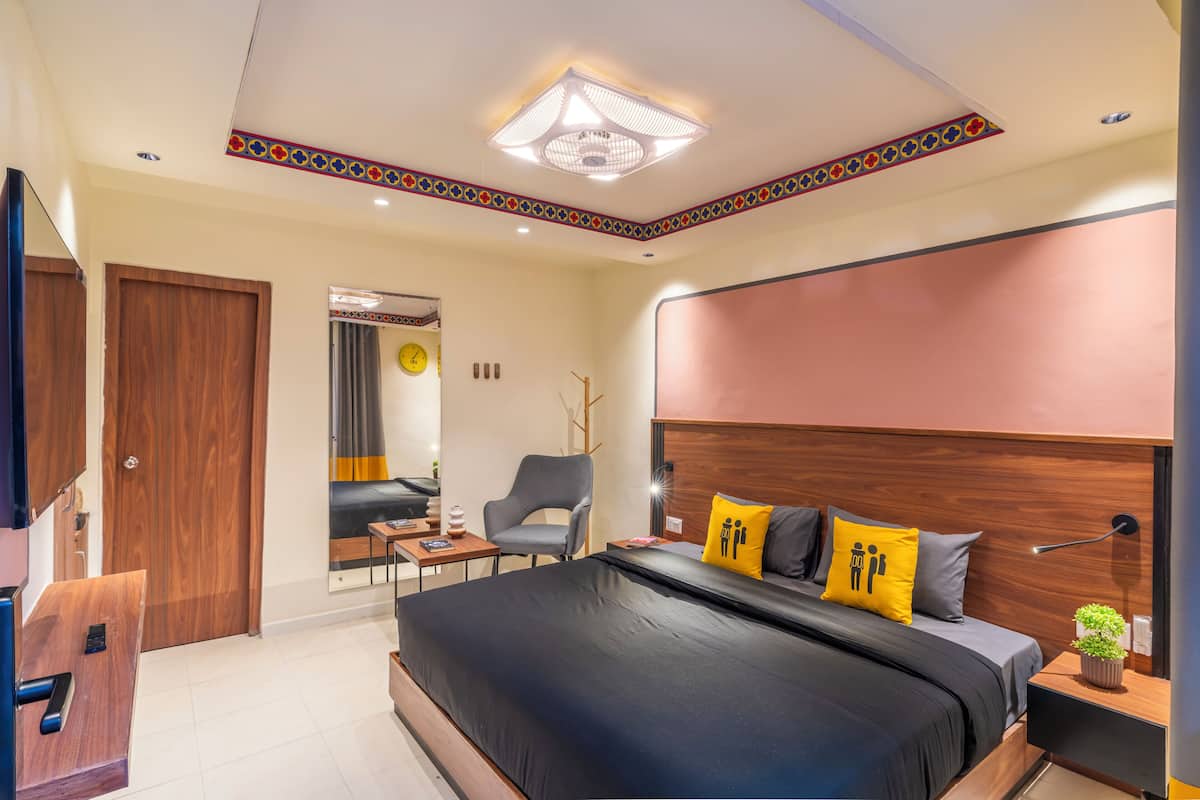 A modern bedroom with a large bed, a desk, and a chair.