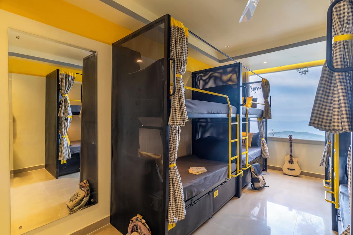 A bunk bed room with a view, a guitar, and a mirror.