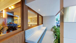 Ein modernes Interieur mit einer Bank, großen Fenstern und Blick auf die Straße.