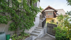 A narrow stone pathway leading to a wooden staircase with a small garden area. - Lakeview Apartments (Hallstatt)