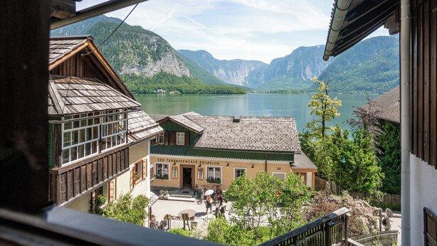 A traditional chalet-style building with a view of a lake and mountains. - Lakeview Apartments (Hallstatt)