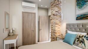 Une chambre à coucher comprenant un lit, une table de chevet, une commode et un mur décoratif en briques.