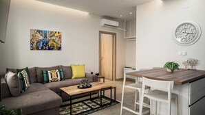 Un salon moderne comprenant un canapé, une table basse et un coin repas avec une table et des chaises en bois.