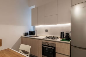 A modern kitchen with a built-in oven, a microwave, a coffee maker, and a refrigerator.