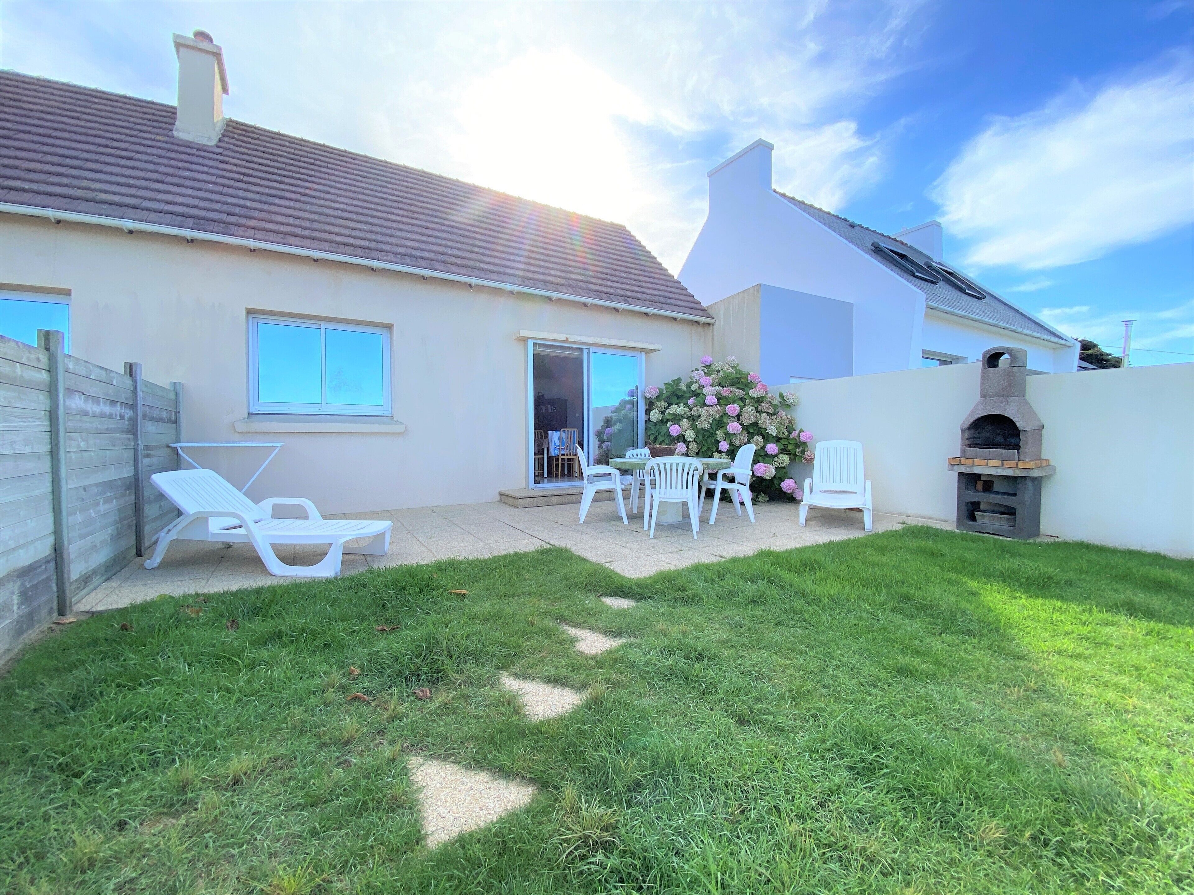A house with a patio, a barbecue area, and a garden.